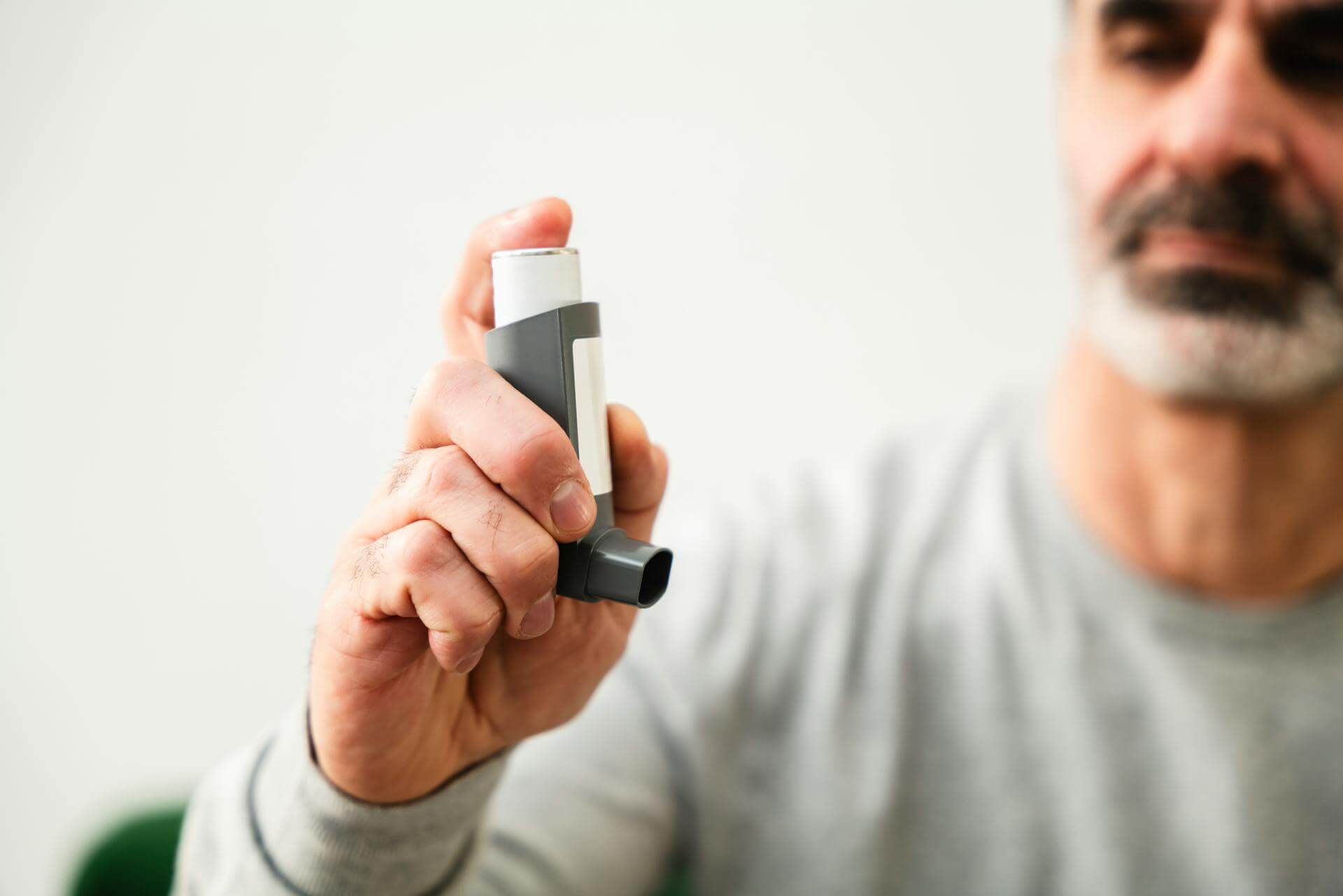 Äldre man med astma inhalator. Få hjälp med astma äldre.