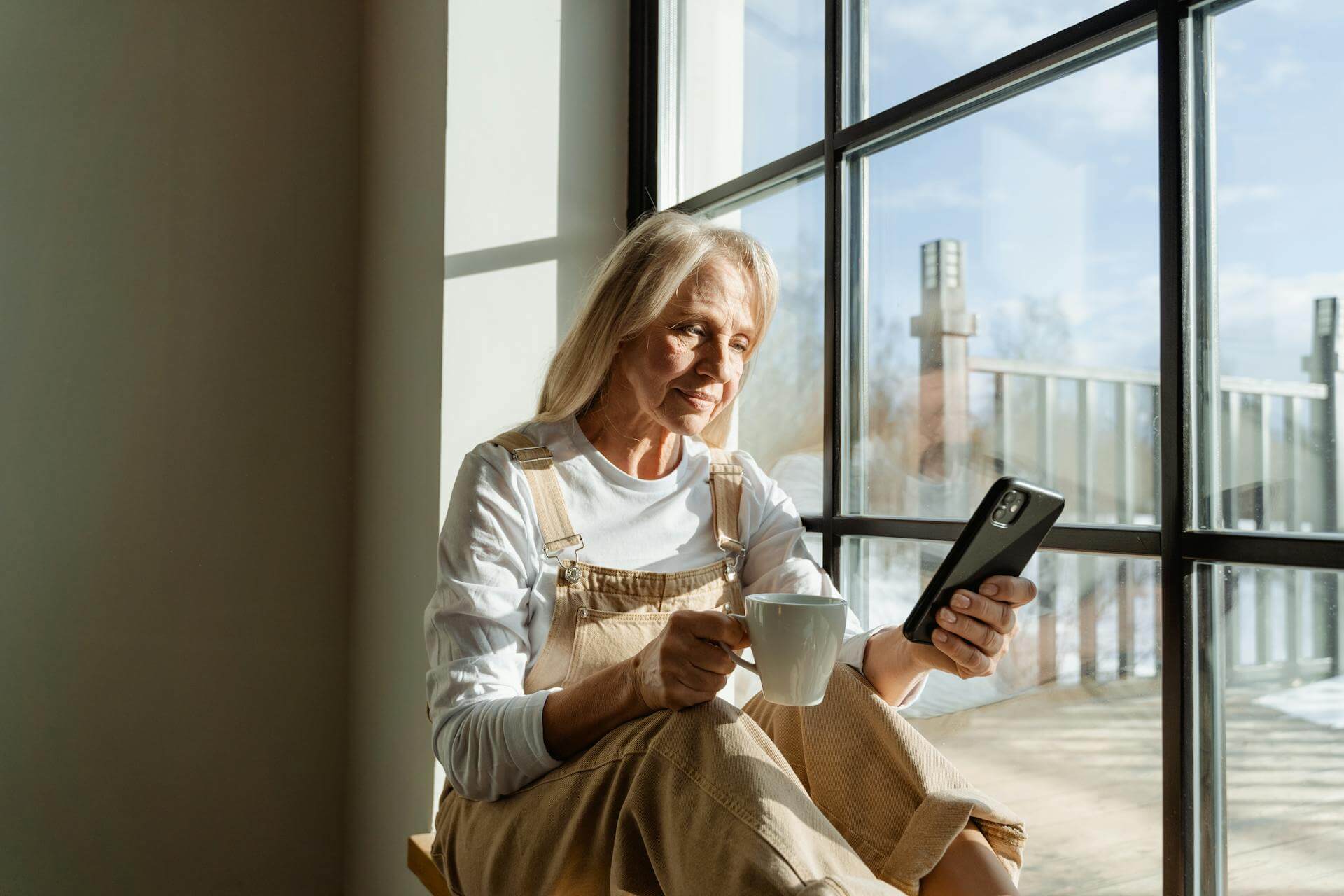 En kvinna som sitter med sin mobil och googlar på "östrogen efter 60 år".